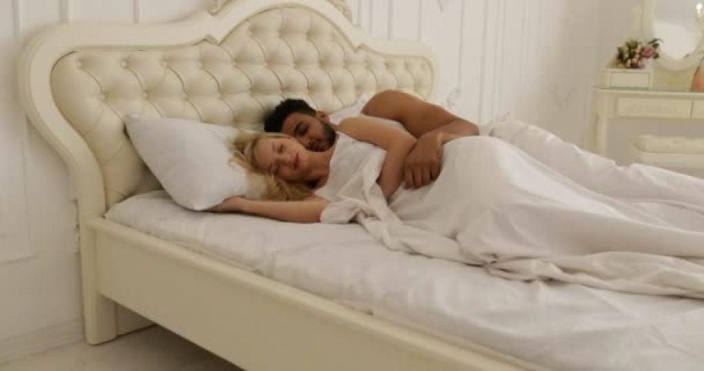 un couple se repose sur leur lit avec un matelas hybride