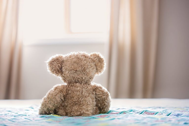 Une peluche posée assise sur un des meilleurs matelas pour le dos