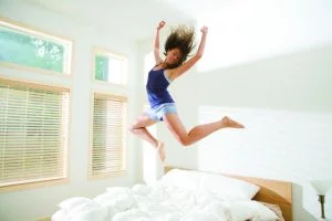 une femme qui saute sur un lit avec matelas à ressorts ensachés