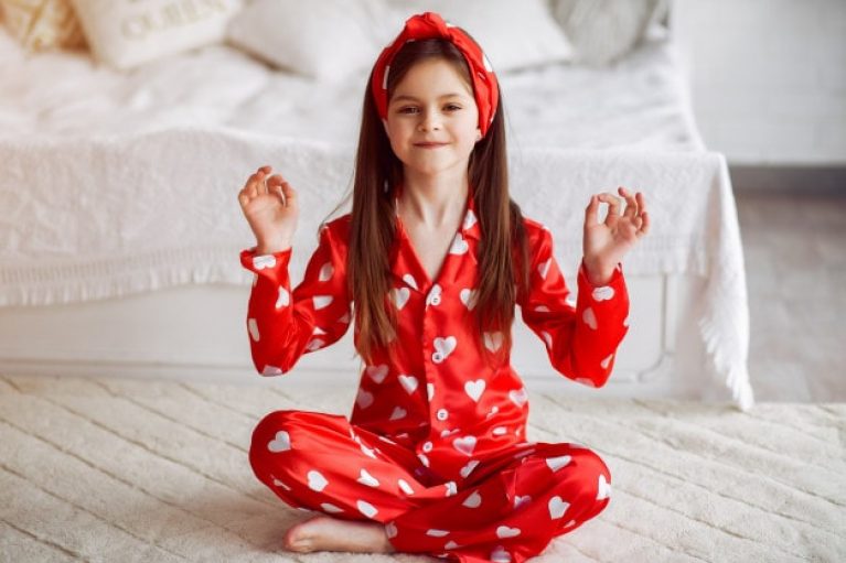 Avis matelas Kipli - petite fille en pyjama indiquant le signe ok avec les mains