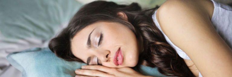 Une femme s'endort sur le côté sur un matelas à mémoire de forme