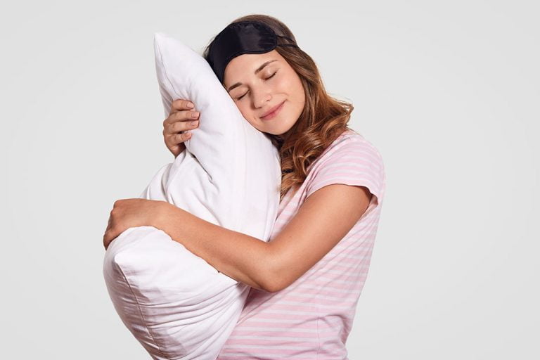 Femme tenant un oreiller en microfibres