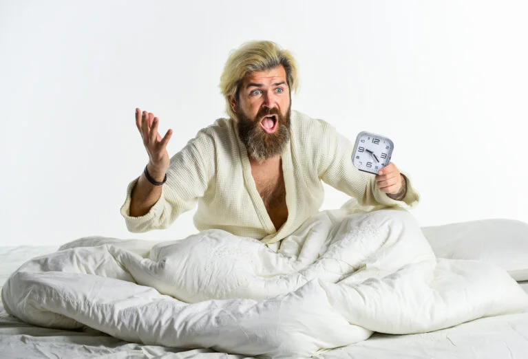 Trouble du sommeil, habitudes saines et mode de vie, la qualité du sommeil que vous obtenez est également importante homme stressé réveil type endormi et réveil au lit homme barbu avec réveil réveil concept